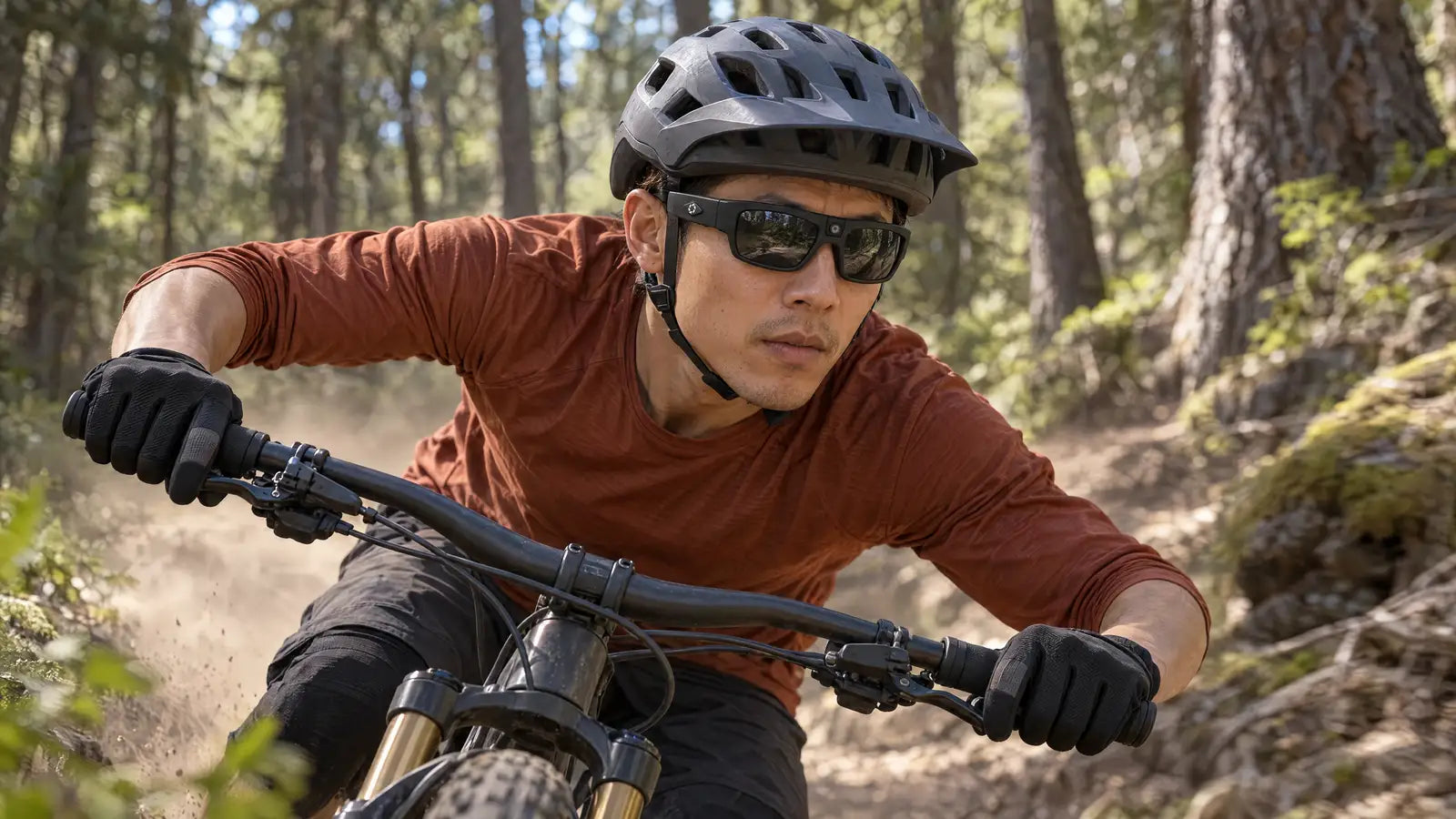 Mountain biker leaning into a forest singletrack turn, wearing Denali camera glasses
