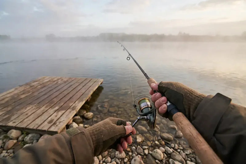 Fishing from a misty lake shore, seen from the angler's eyes